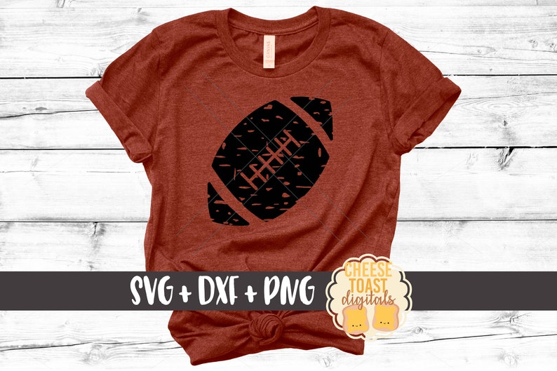 K&ouml;nnte beinhalten: Ein rotes T-Shirt mit einer schwarzen, abgenutzten Football-Grafik. Das Shirt hat einen geknoteten Saum und der Text "SVG + DXF + PNG" und "CHEESE TOAST digitals" ist auf dem Shirt zu sehen.