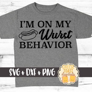Pu&ograve; includere: Una maglietta grigia con il testo "I'm on my Wurst Behavior" e un cartone animato di un hot dog. Il testo "SVG + DXF + PNG" &egrave; nella parte inferiore della maglietta. Un logo per "Cheese Toast Digitals" &egrave; nell'angolo in basso a destra.