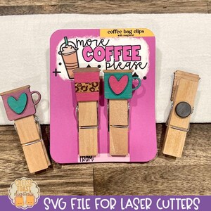 May include: Three wooden clothespins with magnets, decorated with coffee cup designs. The cups have a pink, teal, and leopard print design. The clothespins are packaged on a pink background with the text "more coffee please" and "coffee bag clips".