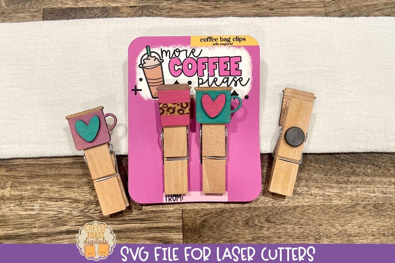 May include: Three wooden clothespins with magnets, decorated with coffee cup designs. The cups have a pink, teal, and leopard print design. The clothespins are packaged on a pink background with the text "more coffee please" and "coffee bag clips".