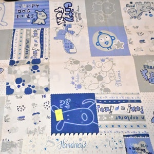 Könnte beinhalten: Ein weißer Stoff mit Patchwork-Muster, das blaue und graue Tierillustrationen zeigt. Der Stoff enthält den Text "Puppy Dog Tails", "City Fox", "Urban Fox! Explorer" und "Mimi".