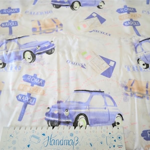 Könnte beinhalten: Weißer Stoff mit einem sich wiederholenden Muster aus blauen Autos, Gepäck und Schildern mit italienischen Städtenamen wie "Roma", "Venedig" und "Neapel".