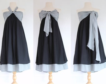 May include: A black dress with a grey bodice and a light blue hem, displayed on a wooden dress form. The top can be styled in multiple ways, including a halter, bow, or draped design. The dress is suitable for various occasions.