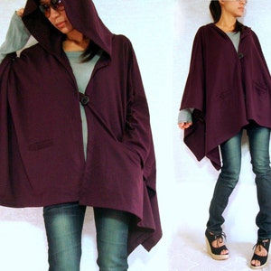 May include: A purple hooded cardigan with a single button closure and two pockets. The cardigan is made of a soft, comfortable fabric and has a relaxed fit.