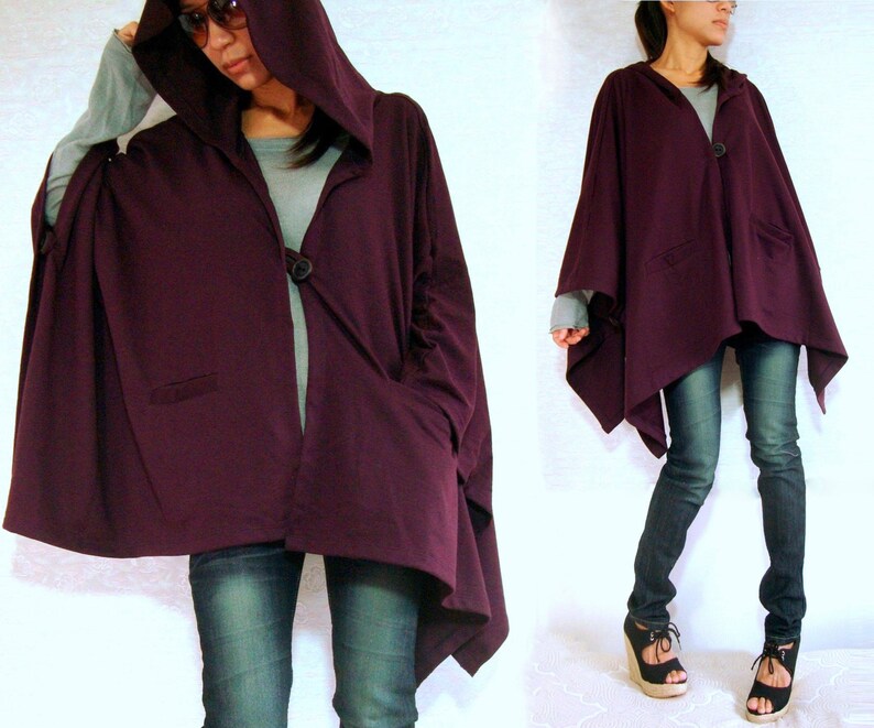 May include: A purple hooded cardigan with a single button closure and two pockets. The cardigan is made of a soft, comfortable fabric and has a relaxed fit.