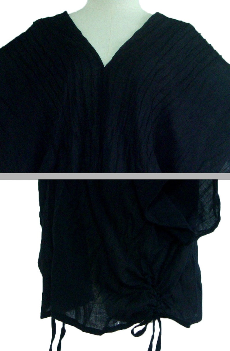 May include: A black, loose-fitting, short-sleeved top with a V-neck and a drawstring at the bottom.