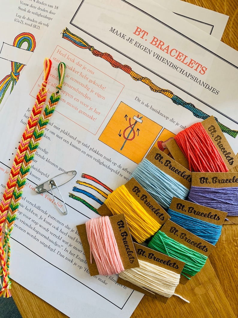 May include: A craft kit for making friendship bracelets. The kit includes colorful embroidery floss, a safety pin, and instructions on how to make the bracelets. The instructions include a diagram of a basic knot.
