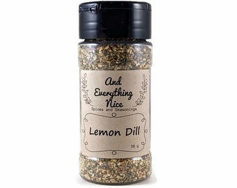 Peut inclure: Un bocal en verre avec un couvercle noir rempli d'un mélange d'herbes et d'épices séchées. L'étiquette est brune avec du texte blanc qui indique "And Everything Nice" et "Lemon Dill".