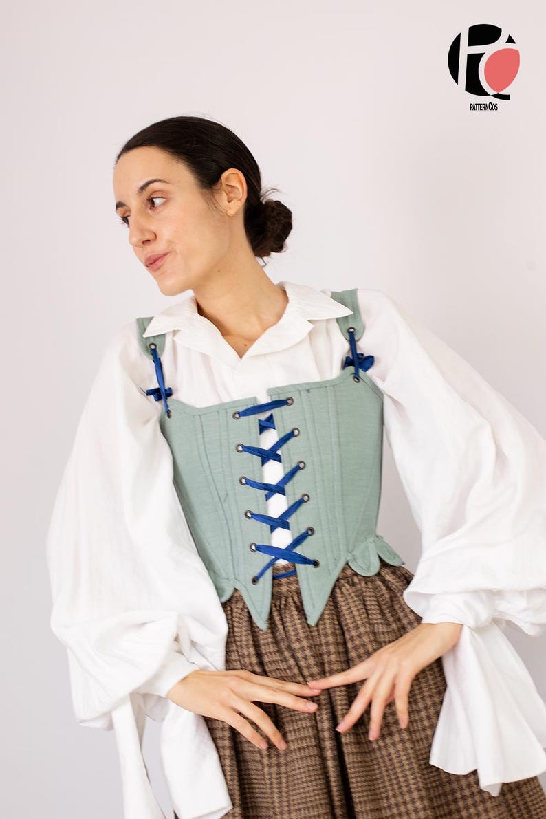 May include: A light green corset with blue ribbon lacing is worn over a white blouse with puffy sleeves. The corset has a square neckline and is paired with a brown plaid skirt. The image is set against a white background.