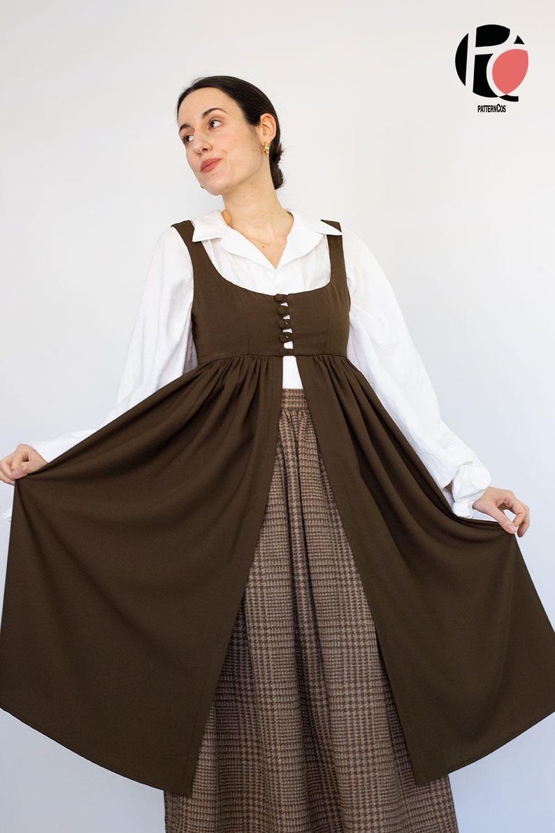May include: A woman wearing a brown dress with a white collared shirt underneath. The dress has a square neckline and button details. The skirt is a brown plaid pattern. The dress is a vintage style.