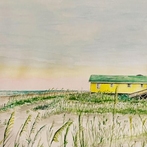 May include: Watercolor painting of a yellow beach house with a green roof, set against a backdrop of a sandy beach and ocean. Tall grasses and a wooden fence are in the foreground. The sky transitions from pink to blue.