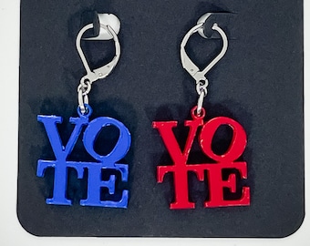 May include: A pair of earrings with silver hooks and blue and red 'VOTE' charms. The charms are made of metal and have a 3D effect.