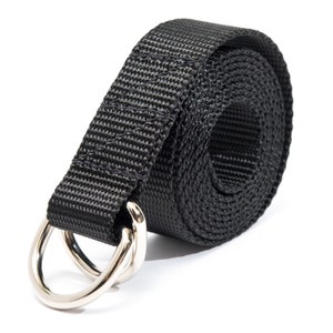 K&ouml;nnte beinhalten: Ein schwarzes Nylonband mit zwei silbernen D-Ringen aus Metall. Das Band ist aufgerollt und die D-Ringe befinden sich am Ende.