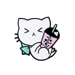 May include: White cat with black eyes and a pink and black boba tea cup with a green straw. The cat is holding the boba tea cup with its paws.