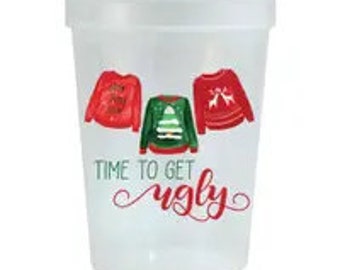 May include: White plastic cup with a Christmas theme. It features three different ugly Christmas sweaters and the text "Time to get ugly".