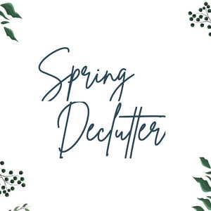 May include: A white background with green leafy branches and berries around the edges. The text "Spring Declutter" is written in a dark blue cursive font in the center of the image.