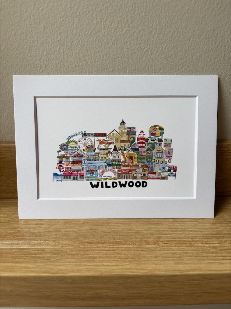 May include: A colorful illustration of the Wildwood, New Jersey boardwalk, featuring iconic landmarks and attractions, including a Ferris wheel, a lighthouse, and a roller coaster. The text "WILDWOOD" is printed below the illustration.