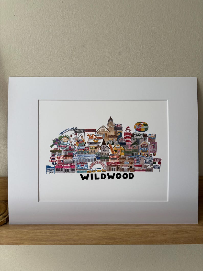 May include: A colorful illustration of the Wildwood boardwalk in New Jersey. The illustration features various shops, restaurants, and attractions, including a Ferris wheel, a roller coaster, and a water park. The text "WILDWOOD" is written in black letters at the bottom of the illustration.