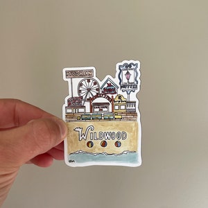 May include: A colorful illustration of a Wildwood, New Jersey boardwalk scene with a Ferris wheel, shops, and beach balls. The text "Wildwood" is written in a stylized font.