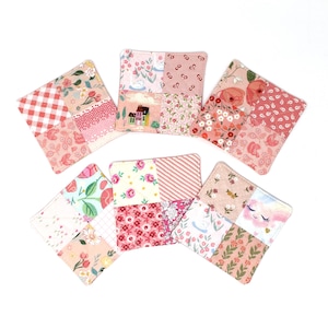 May include: Six square fabric coasters featuring a patchwork design of various pink, red, and white floral, gingham, and striped patterns. Each coaster is constructed from four distinct fabric squares stitched together with visible quilting.