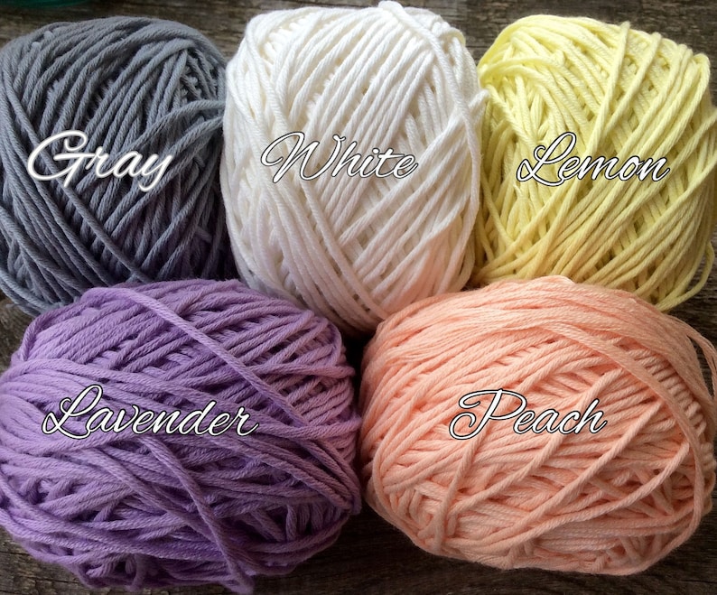 May include: Five balls of yarn in different colors: gray, white, lemon yellow, lavender, and peach.