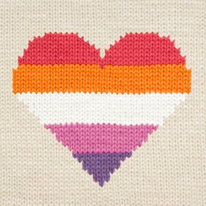 Puede incluir: Un corazón tejido en los colores de la bandera del orgullo lésbico. El corazón está hecho de hilo rosa, naranja, blanco, rosa claro y morado.