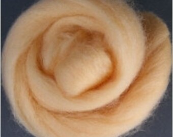May include: A close-up of a light peach-colored wool roving. The roving is soft and fluffy, and it is perfect for spinning or felting.