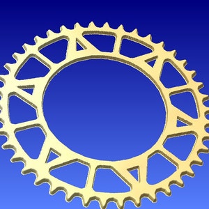May include: A gold-colored metal bicycle chainring with a circular design and a series of triangular cutouts.