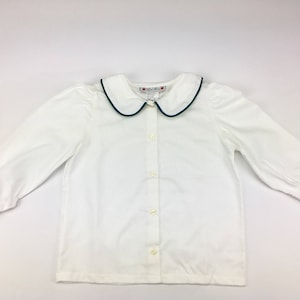 May include: White long-sleeve button-down shirt with a green trim collar. The shirt has a classic, collared design and is perfect for a variety of occasions.
