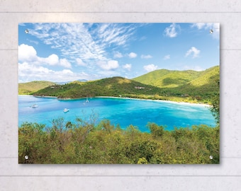 May include: A panoramic view of a tropical island with a turquoise bay, lush green hills, and a white sandy beach. The sky is blue with white clouds.