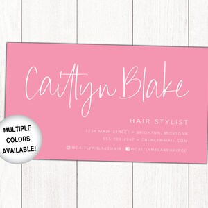 May include: Pink business card with white text for a hair stylist named Caitlyn Blake. The card includes the business's address, phone number, email address, and social media handles. A white circle with black text reads "Multiple Colours Available!"