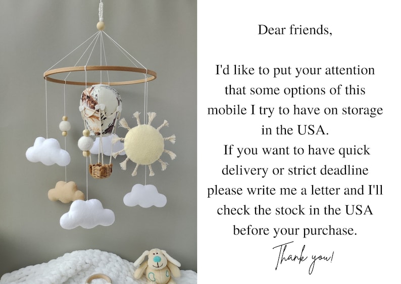 May include: A white, beige, and brown baby mobile with a hot air balloon, clouds, and a sun. The mobile is hanging from a wooden ring. The text "Dear friends, I'd like to put your attention that some options of this mobile I try to have on storage in the USA. If you want to have quick delivery or strict deadline please write me a letter and I'll check the stock in the USA before your purchase. Thank you!" is written on a white background.