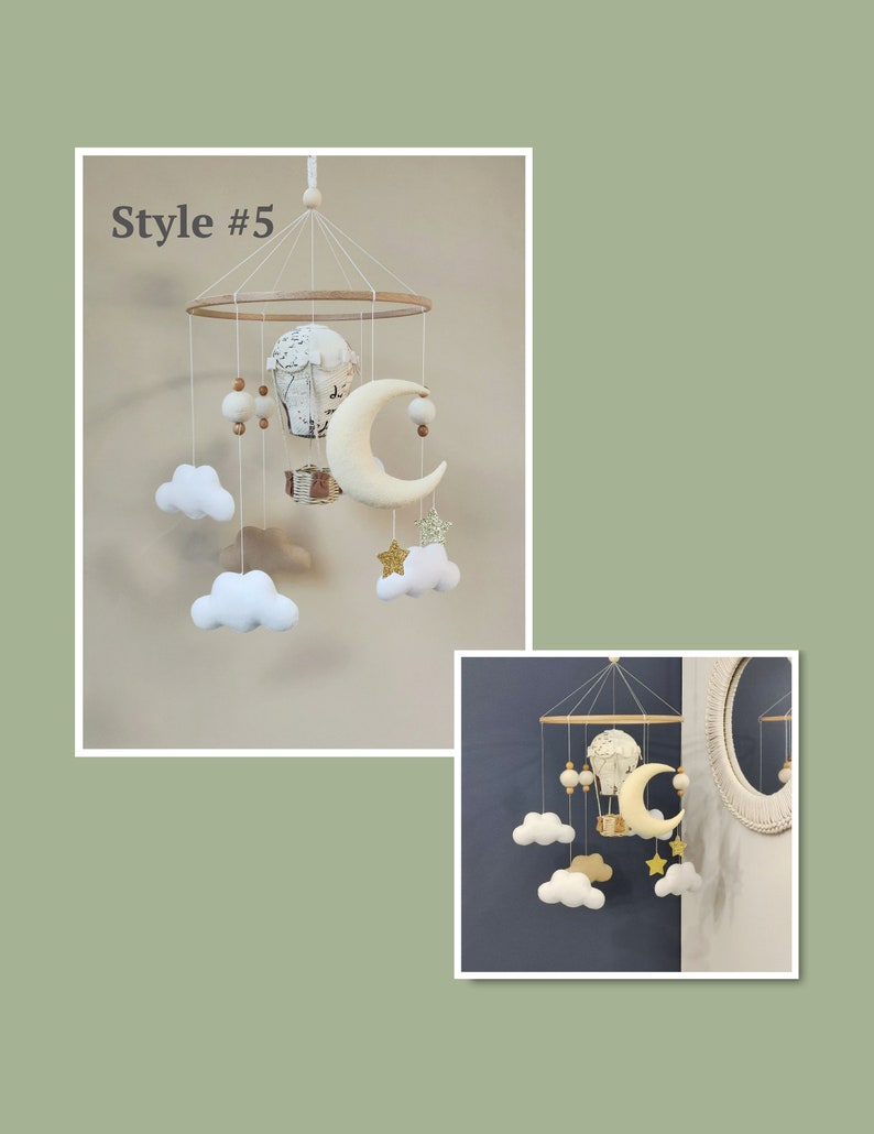 May include: A white and beige baby mobile with a hot air balloon, clouds, a crescent moon, and stars. The mobile is hanging from a wooden ring.