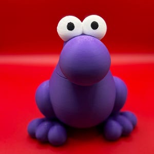 May include: A purple, cartoonish creature with large white eyes and black pupils. The figure has a rounded body, a large nose, and small feet. The background is a solid red.