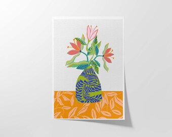 Op de afbeelding: Een groene en blauwe gepatroneerde vaas met een boeket roze en oranje bloemen. De vaas staat op een gepatroneerde oranje achtergrond.