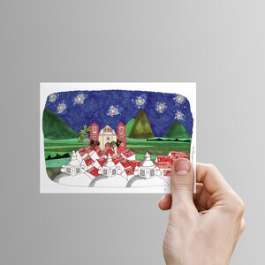 Puede incluir: Una pintura de acuarela de un peque&ntilde;o pueblo de noche con un cielo estrellado. El pueblo est&aacute; formado por casas blancas con techos rojos y una gran iglesia en el centro. Hay dos colinas verdes en el fondo.