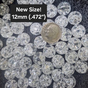 May include: A collection of clear, round crackle glass beads, each measuring 12mm (.472 inches) in diameter. A silver-colored US dime coin is placed among the beads for scale, and a black text box displays the text New Size! 12mm (.472").