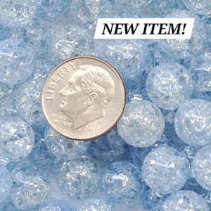 May include: A close-up of a pile of light blue glass beads with a frosted finish. The beads are about the size of a US dime.  NEW ITEM!