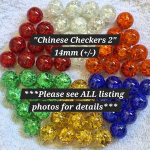 May include: A collection of round, crackle-glass marbles in red, orange, yellow, green, blue, and clear. The text "Chinese Checkers 2" "14mm (+/-)" and "***Please see ALL listing photos for details***" is overlaid on the marbles.