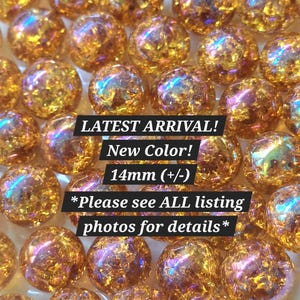May include: A collection of round, 14mm beads featuring a gold-toned, iridescent, and textured finish. The image includes text that reads: LATEST ARRIVAL! New Color! 14mm (+/-) *Please see ALL listing photos for details*.