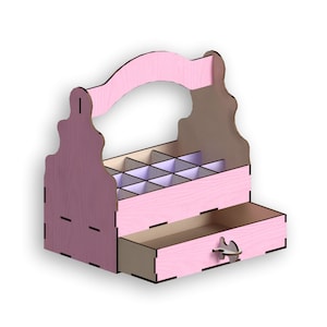 Puede incluir: Organizador de madera rosa con asa, cajón y varios compartimentos. El organizador está diseñado para guardar objetos pequeños como joyas o cosméticos.