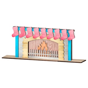 Puede incluir: Una chimenea de madera con un fondo pintado de azul y blanco. Calcetines rosas cuelgan de la repisa de la chimenea, y un recorte de fuego est&aacute; en la abertura de la chimenea.