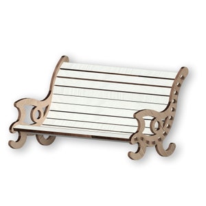 Puede incluir: Banco de madera blanco con patas de madera talladas ornamentadas. El banco tiene un diseño de listones y es perfecto para un jardín o una terraza.