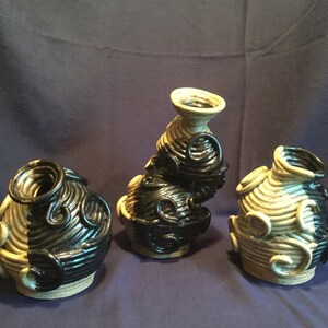 Puede incluir: Tres jarrones de cerámica con un diseño de espiral en blanco y negro. Los jarrones son de diferentes formas y tamaños.