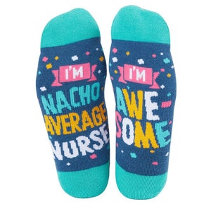Op de afbeelding: Een paar blauwe sokken met een kleurrijk ontwerp. De sokken zeggen "I'm Nacho Average Nurse" en "I'm Awesome".