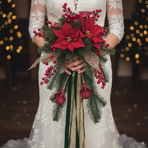 May include: A festive bridal bouquet featuring vibrant red poinsettias, berries, and calla lilies, accented with evergreen foliage and gold decorative elements. Green and gold ribbons cascade from the arrangement, creating a beautiful holiday-themed floral display.
