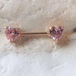 Piercing para pezón de acero quirúrgico en oro rosa con corazones rosas y circonitas. 14 g, 12 mm o 16 mm (uno solo).