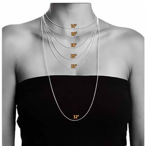 May include: A model wearing a silver chain necklace in various lengths, from 14 inches to 32 inches. The necklace is shown on a person with a black top.