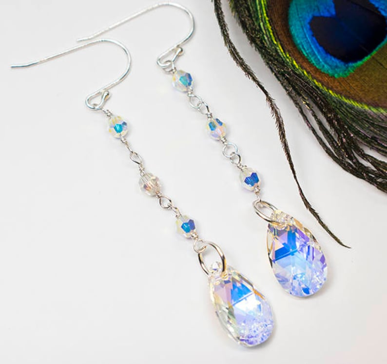 May include: A pair of silver dangle earrings with iridescent crystal teardrop charms and small crystal beads.