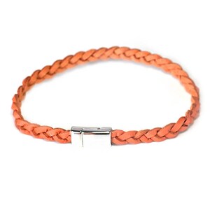 May include: A braided leather bracelet in a bright orange color with a silver clasp.